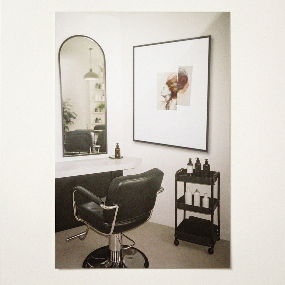 Chevelures 01 framed print, black matt floater frame, in a hair salon beside an arched mirror and styling chair — Beau Edition